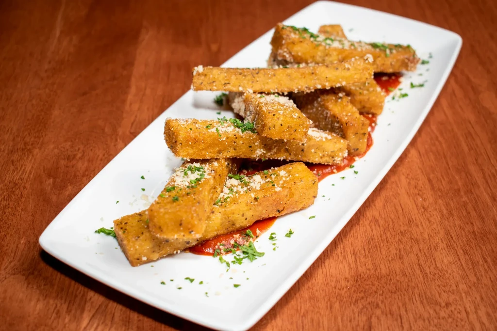 Rectangular fried sticks with Parmesan, parsley, and marinara sauce.