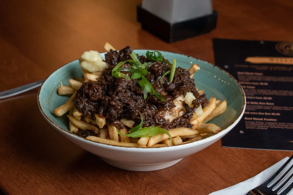 Braised beef poutine with cheese curds, gravy, and green onions.