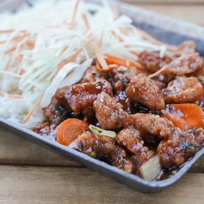 Sauced crispy chicken, white rice topped with carrots and shredded cabbage.