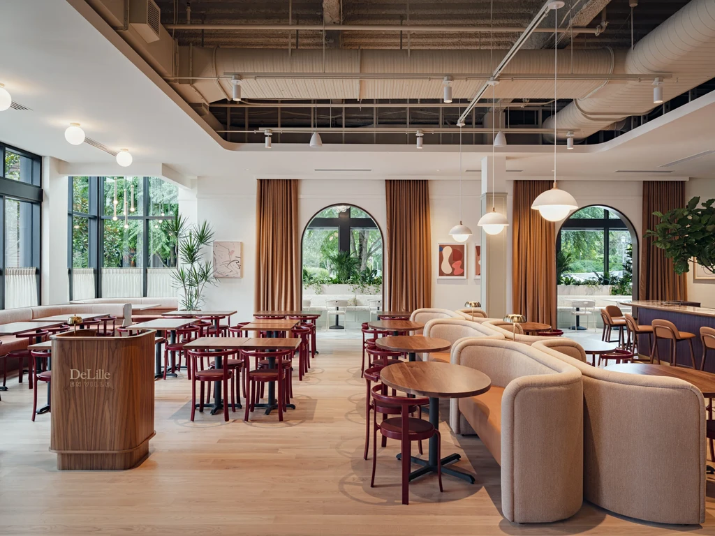 Modern DeLille EN VILLE restaurant interior with dining area, bar, and windows.