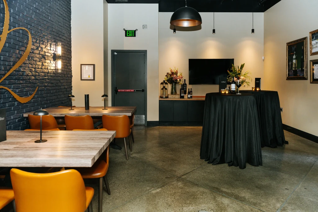 Modern restaurant interior with dining tables, brick wall, and wine display.