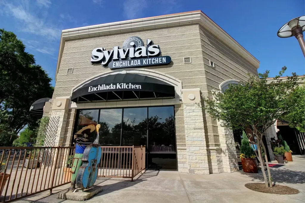 Exterior of Sylvia's Enchilada Kitchen with mariachi sculpture and patio.