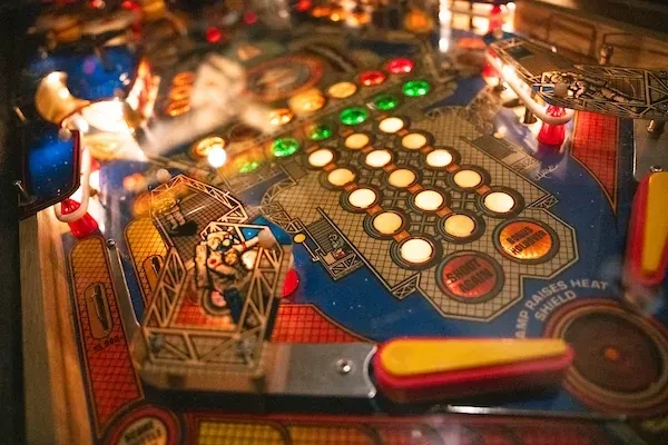 Close-up of a pinball machine's playfield with lit targets and flippers.