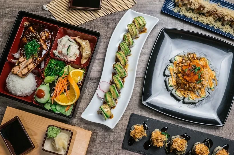 Overhead view of a wooden table laden with various Japanese dishes.