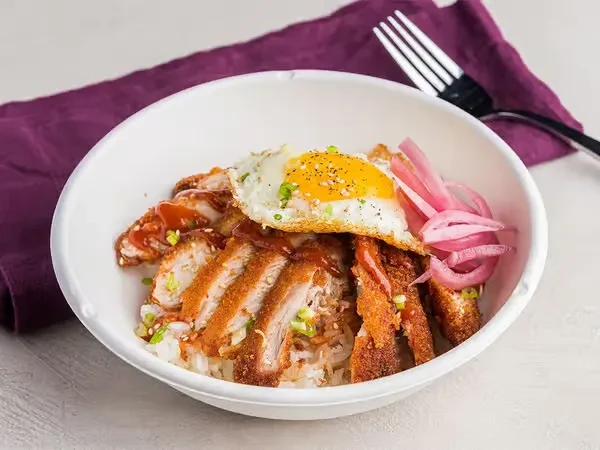 Rice bowl with fried meat, egg, and pickled red onions.