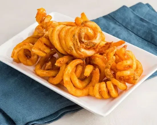 White plate piled high with golden-brown curly fries.