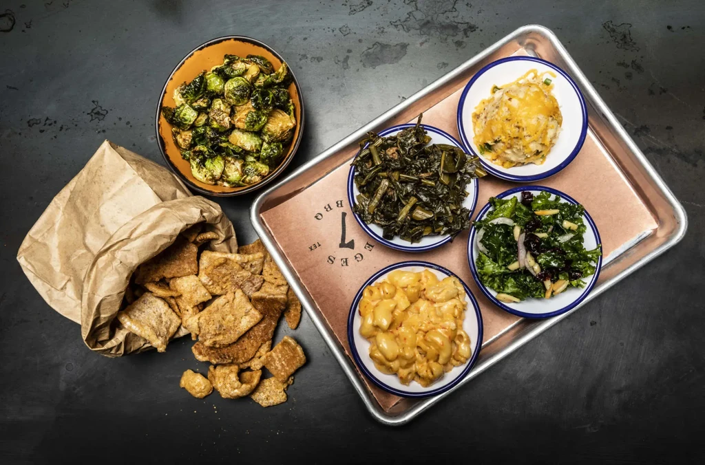 Overhead view of several comfort food dishes on a dark surface.
