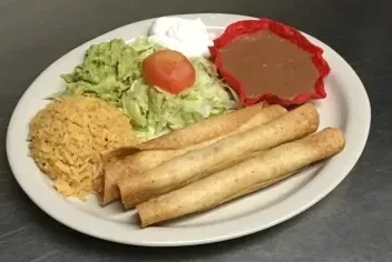 Plate of Mexican food with taquitos, rice, and beans.