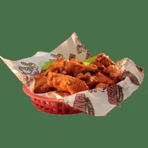 Crispy, saucy chicken wings with celery sticks in a red basket.