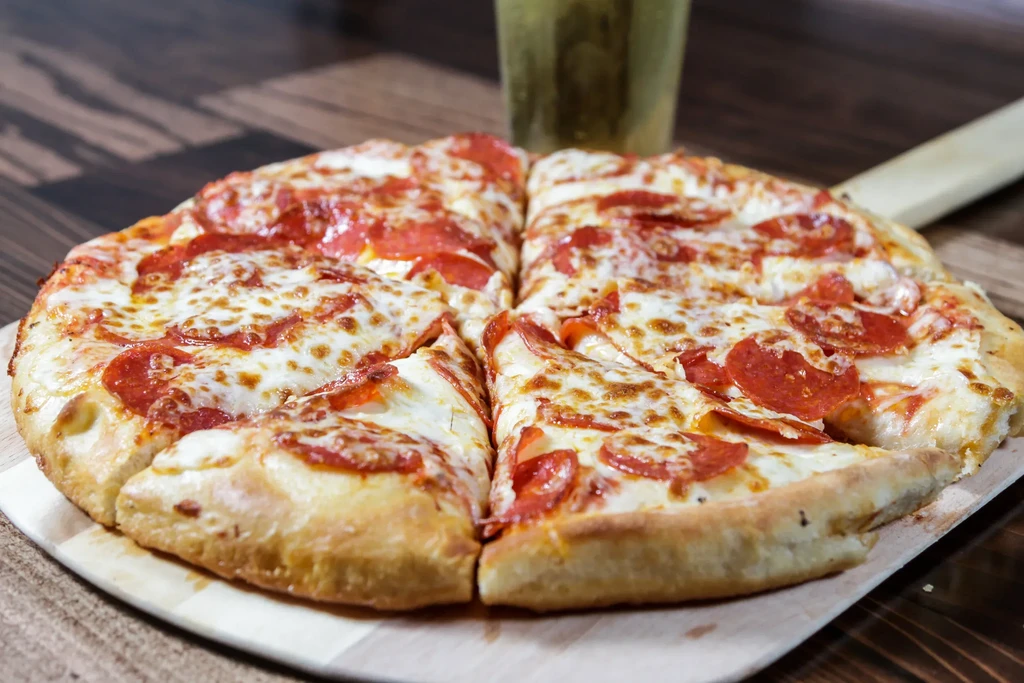 Pepperoni pizza on a wooden pizza peel.