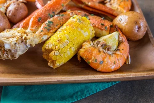 Seafood boil with crab legs, corn, potatoes, and shrimp.
