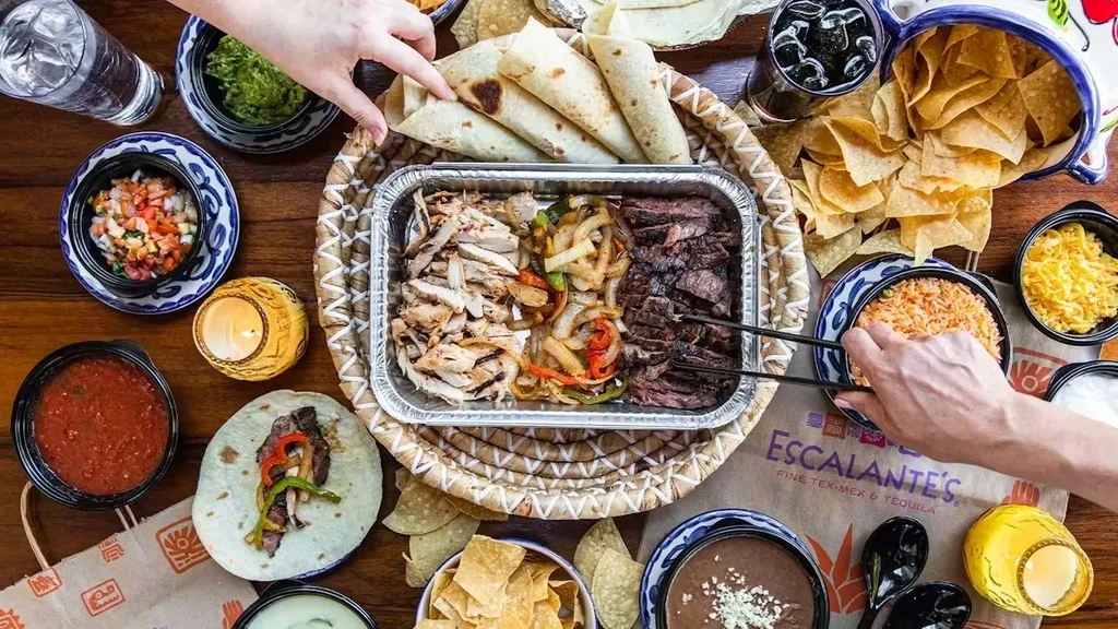 Overhead shot of a table laden with Tex-Mex fajitas and sides.