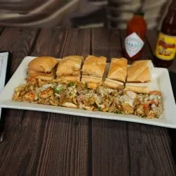 Platter with po'boy sandwich, rice, shrimp, and melted cheese.