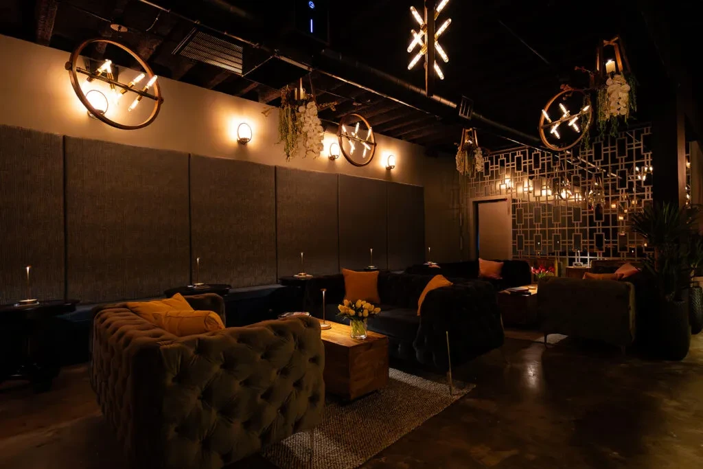 Stylish, dimly lit lounge with diverse seating and warm lighting.