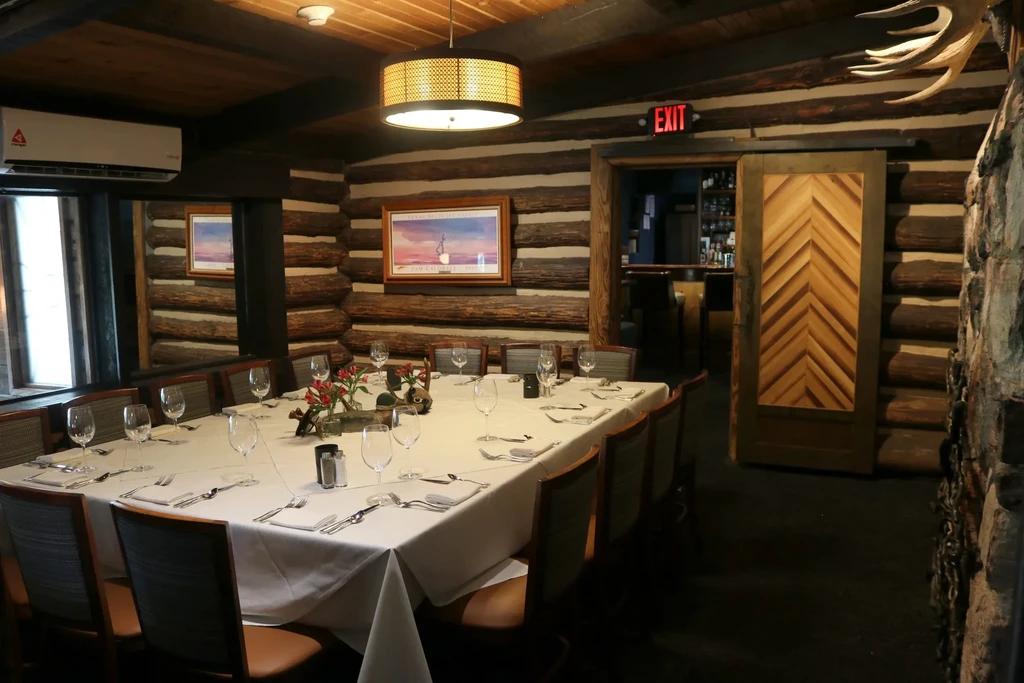 Rustic restaurant interior with a long dining table set for guests.