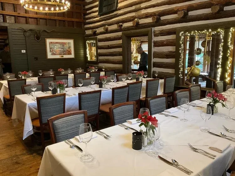 Rustic dining hall with long tables set for a meal.