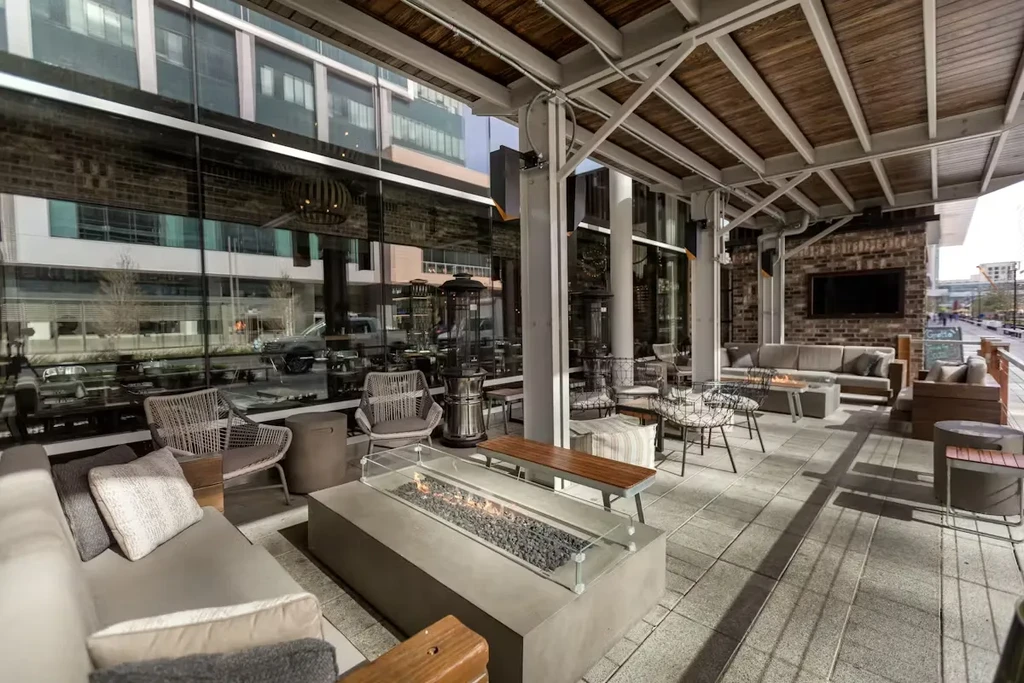Outdoor patio with fire pit, varied seating, and overhead roof.
