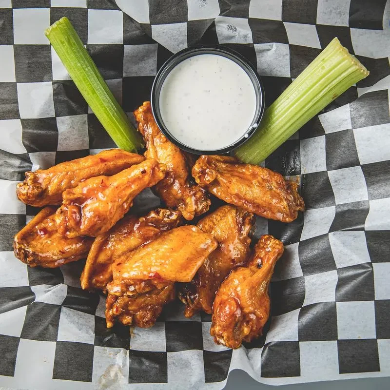 Top-down view of chicken wings, celery, and dipping sauce.