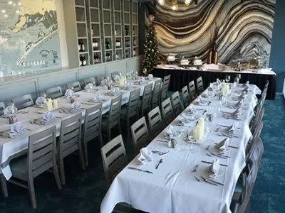 Restaurant dining area set for an event with long tables and buffet.