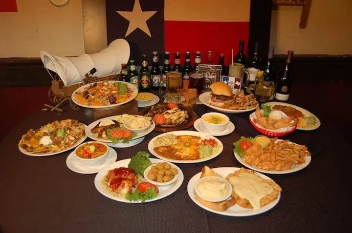 Table laden with Texan food, drinks, and a Texas flag.