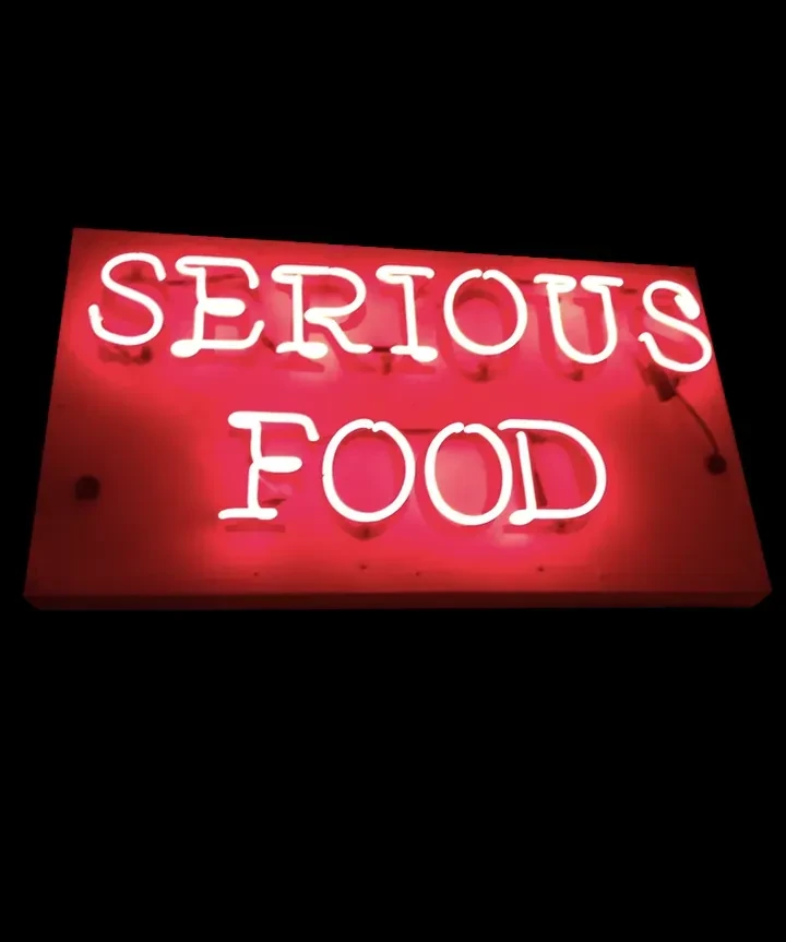 Red neon sign with white text: "SERIOUS FOOD".