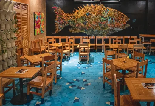 Restaurant dining area with blue tiled floor and fish mural.
