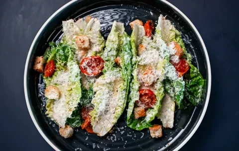 Caesar salad with Romaine, Parmesan, croutons, and halved cherry tomatoes.