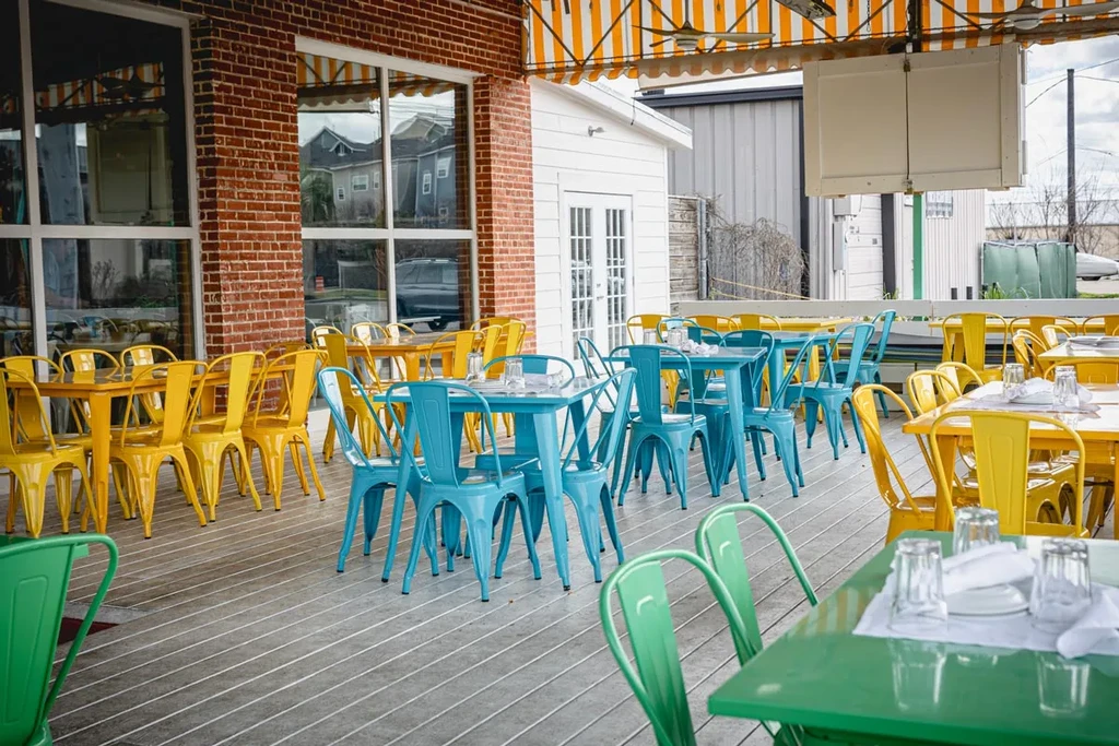 Outdoor restaurant patio with colorful tables and chairs.