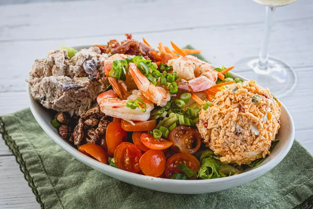 Close-up of a white bowl filled with a colorful shrimp salad.