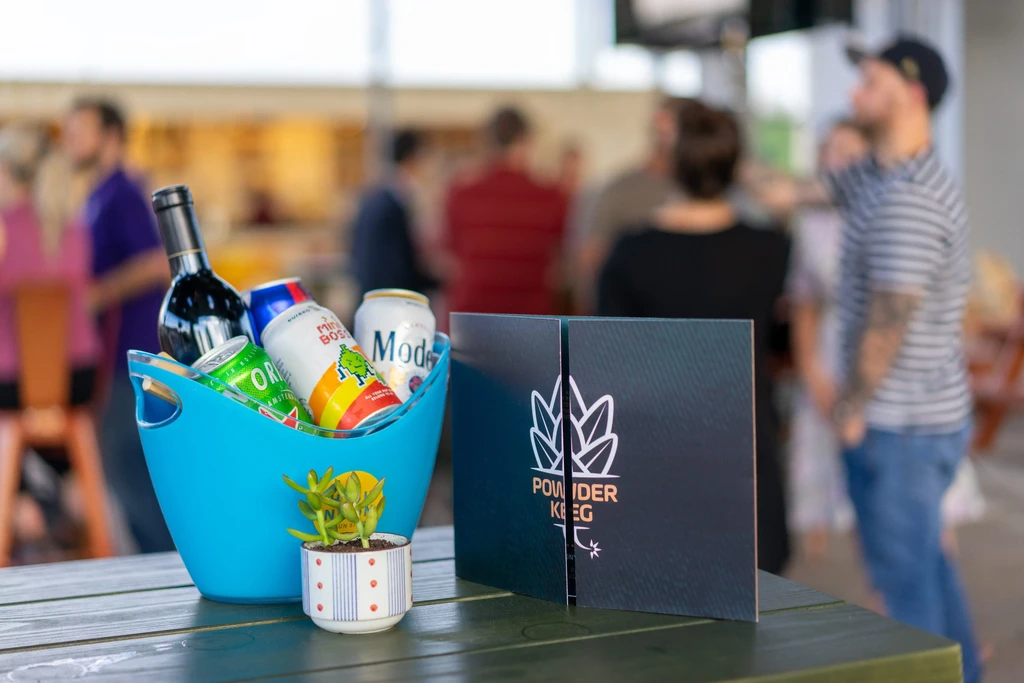 Turquoise bucket with wine, beer, and a "POWDER KEG" sign.