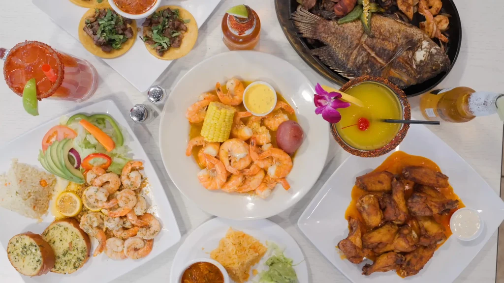 Overhead shot of a table laden with various seafood dishes and drinks.