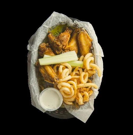 Overhead view of a basket of fried chicken wings and fries.