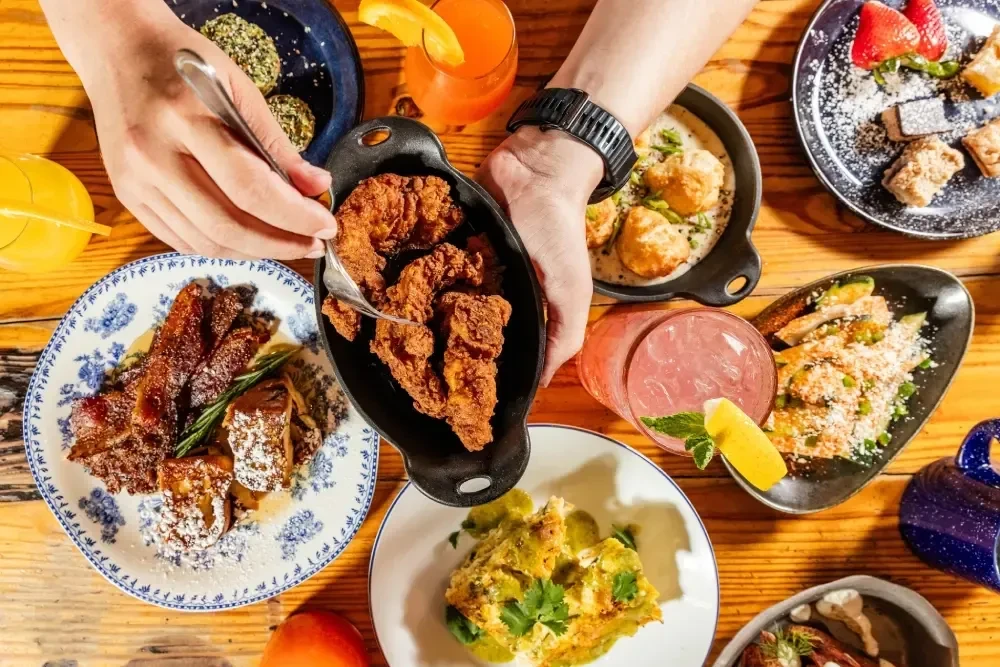 Top-down view of a dining table laden with various food and drinks.