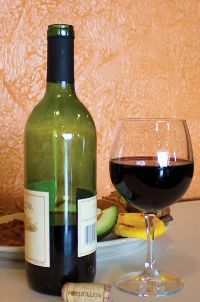 Green wine bottle, glass of red wine, cork with "FOXHOLLOW".