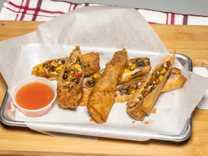 Crispy spring rolls with corn and black bean filling, dipping sauce.