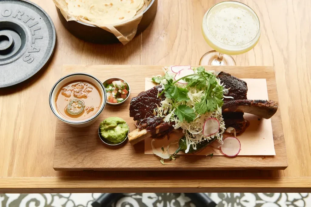 Overhead view of a meal with braised short ribs and sides.