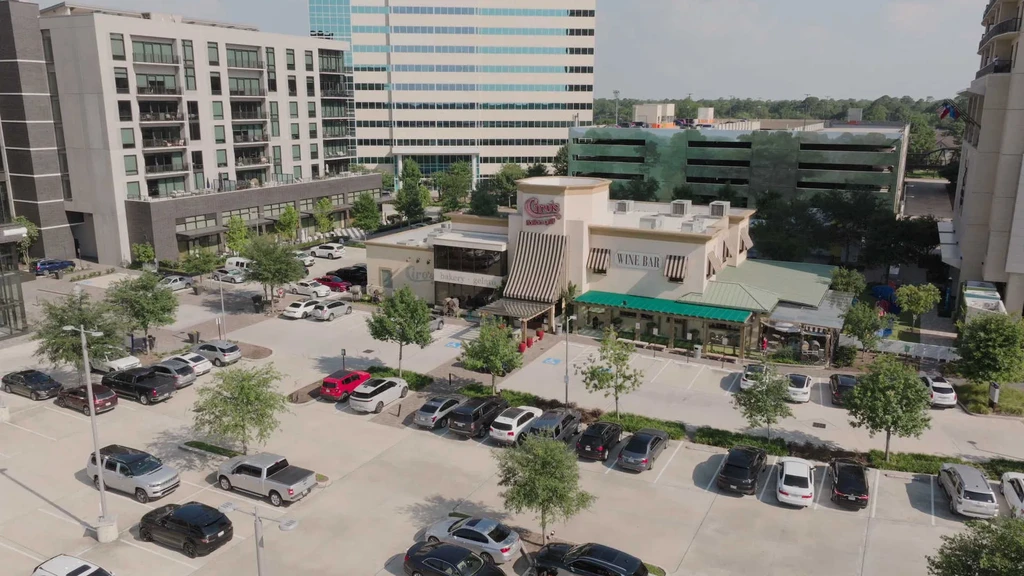 Aerial view of urban landscape with commercial buildings and parking lot.