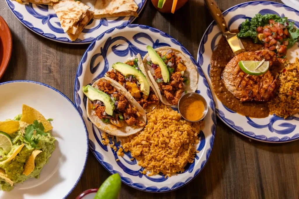 Overhead view of a spread of Mexican food on a wooden table.