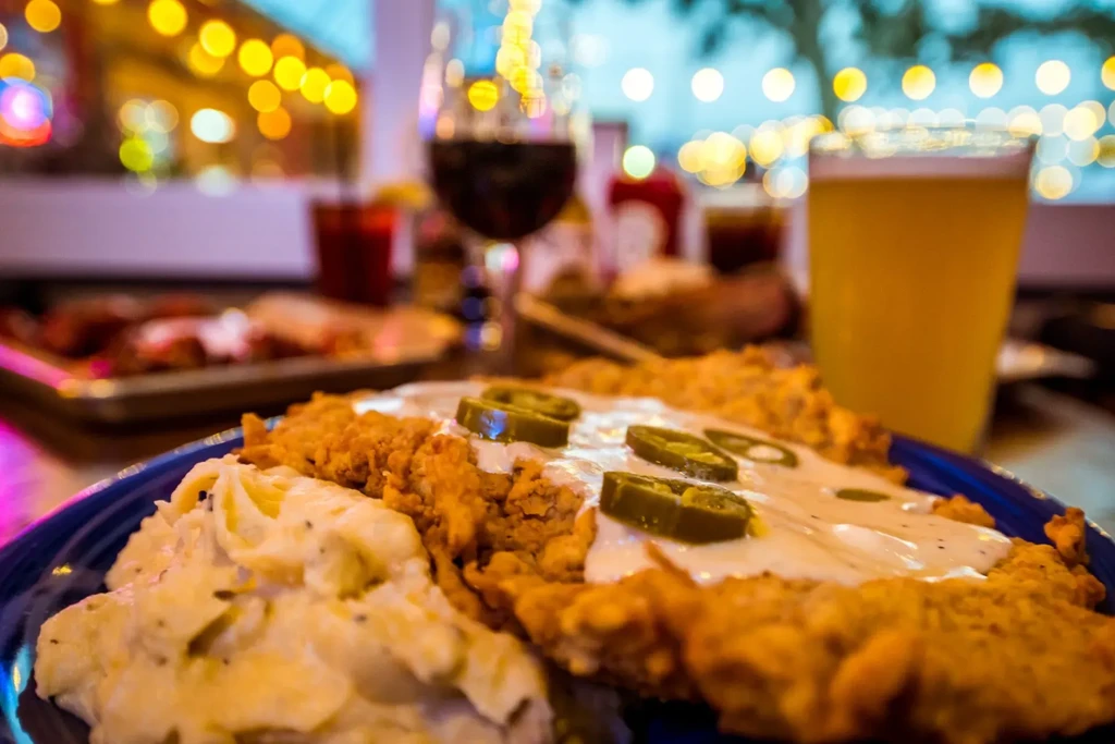 Fried chicken steak with gravy, jalapeños, and mashed potatoes.