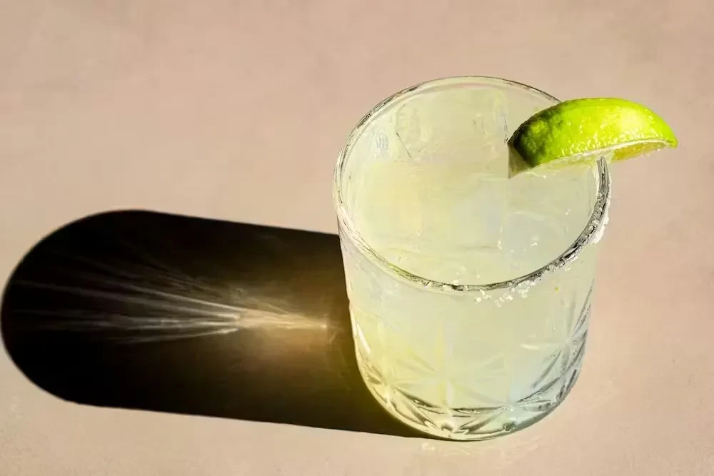 Top-down view of a salted cocktail with a lime wedge.