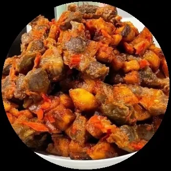 Close-up of stir-fried meat and vegetables in a white bowl.