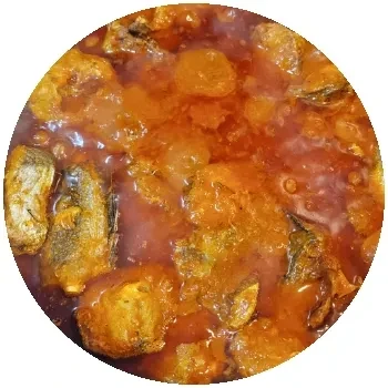 Close-up, top-down view of a reddish-orange fish or meat stew.