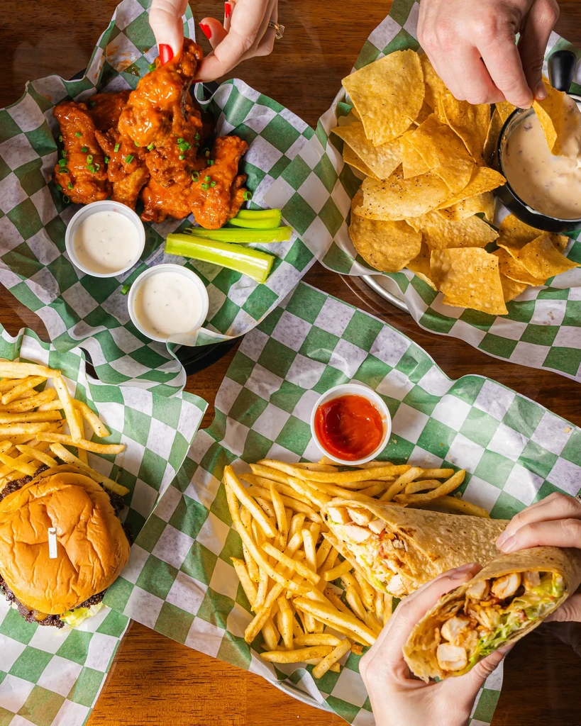 Overhead shot of a wooden table with casual restaurant food.