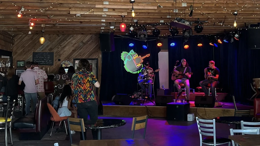 Live band performing on stage in a lively, intimate bar.