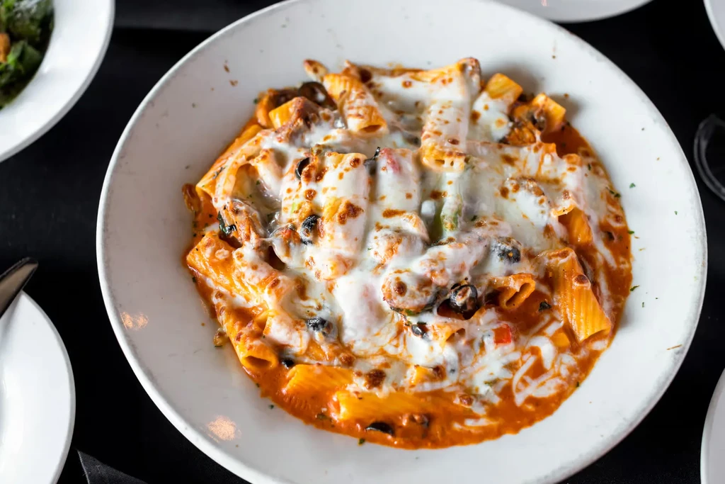 Close-up overhead shot of baked ziti with melted cheese.