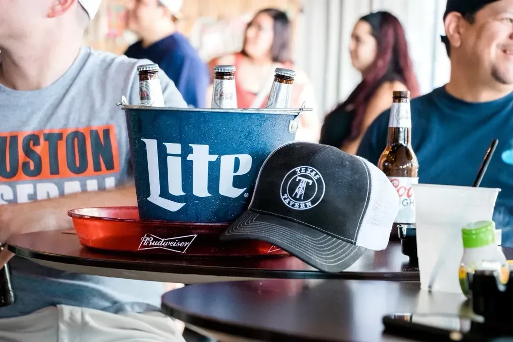 Miller Lite beers in an ice bucket with a Texas Tavern hat.