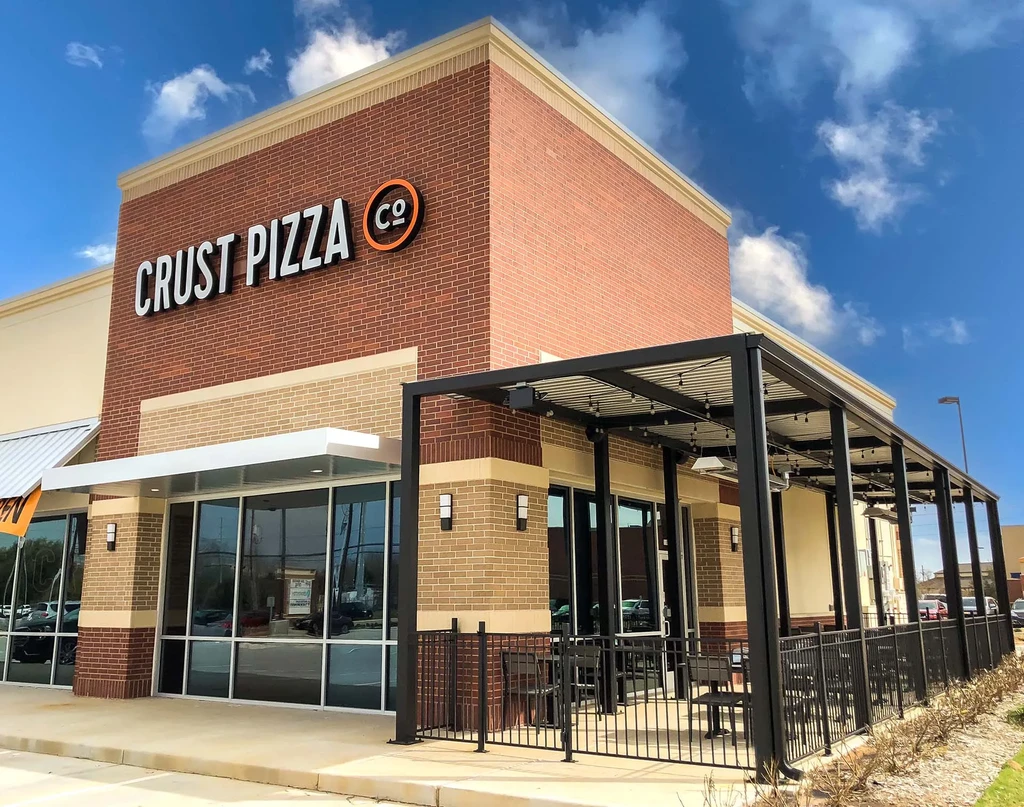Exterior of Crust Pizza Co. restaurant with an outdoor patio.