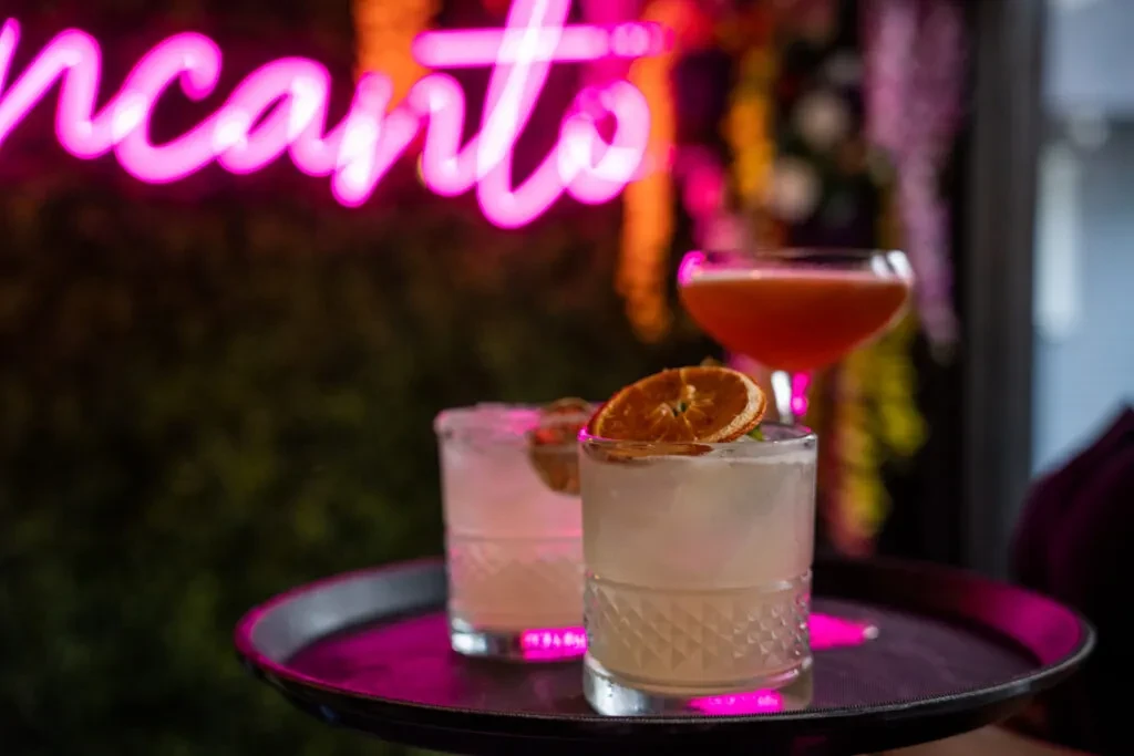 Three cocktails, two in clear glasses, one in a coupe glass.