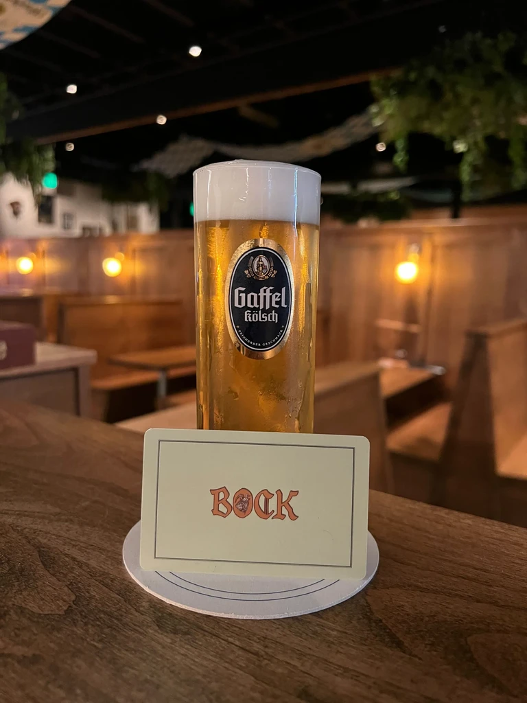 Golden Gaffel Kölsch beer, "BOCK" card, on a wooden pub table.