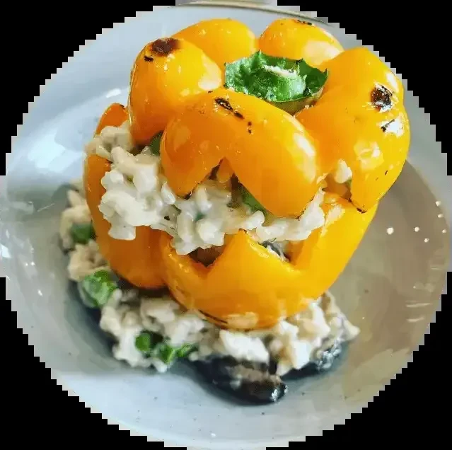 Roasted yellow bell pepper stuffed with creamy rice and basil garnish.